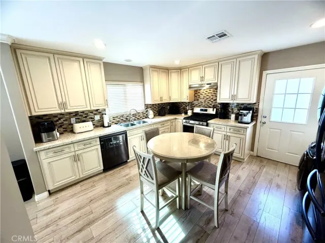 a kitchen with a table chairs sink and cabinets