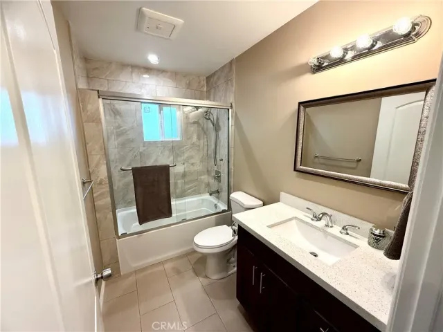 a bathroom with a sink a toilet a mirror and shower