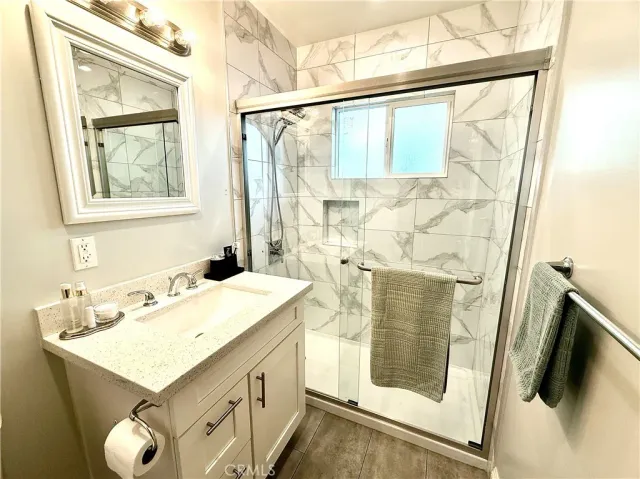 a bathroom with a sink and mirror with bathtub