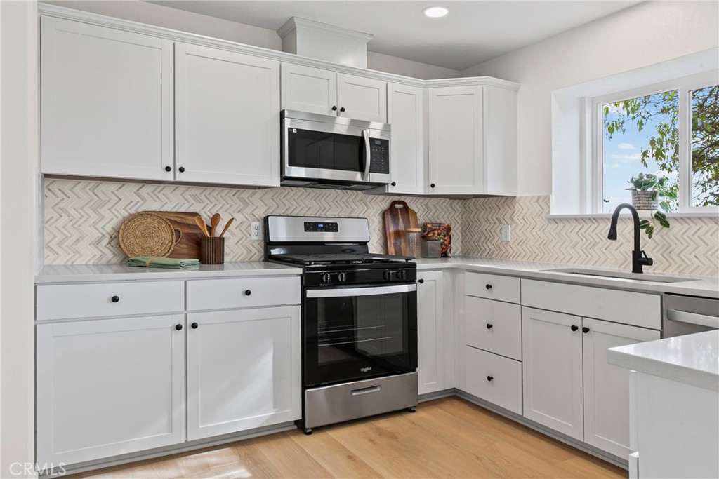 5658 Prancing Deer Road Paso Robles, CA 93446 - Photo 6 of 31 a kitchen with white cabinets stainless steel appliances and sink
