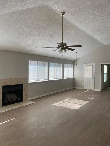 a view of an empty room with a fireplace and a window