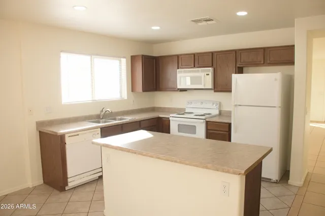 a kitchen with a sink a stove a refrigerator and white cabinets