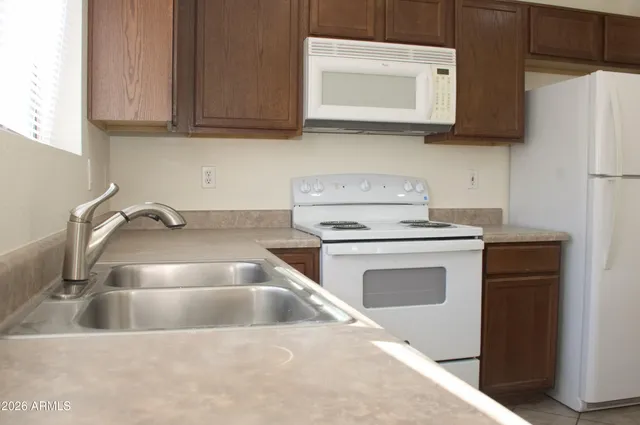 a kitchen with granite countertop a sink and a stove top oven