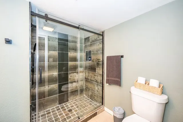 a bathroom with a toilet and a shower