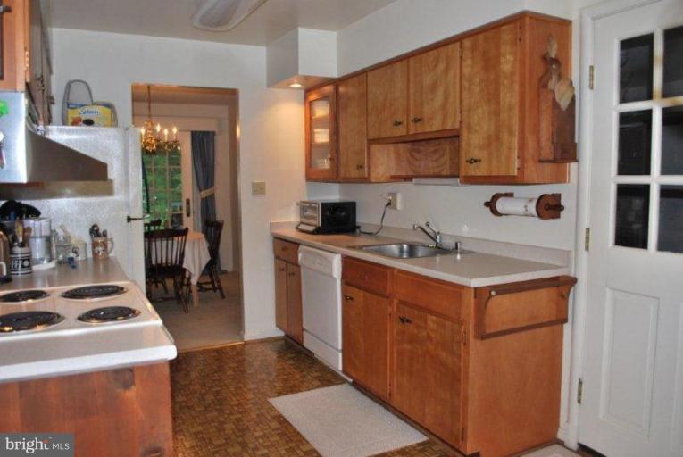 13233 Clifton Road Silver Spring, MD 20904 - Photo 11 of 30 a kitchen with a sink a stove and cabinets