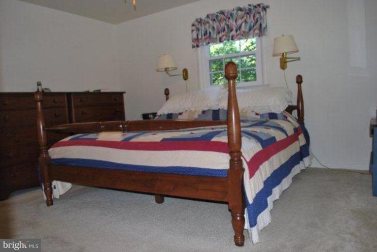 13233 Clifton Road Silver Spring, MD 20904 - Photo 15 of 30 a bed sitting in a room next to a lamp