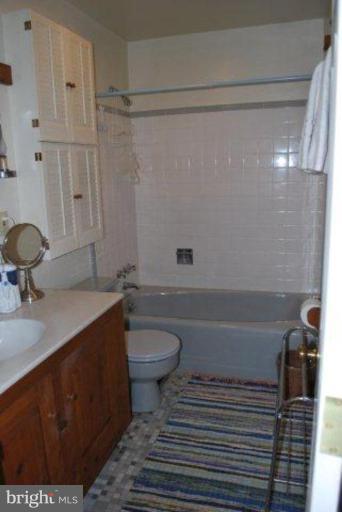 13233 Clifton Road Silver Spring, MD 20904 - Photo 20 of 30 a bathroom with a granite countertop sink toilet a mirror and bathtub