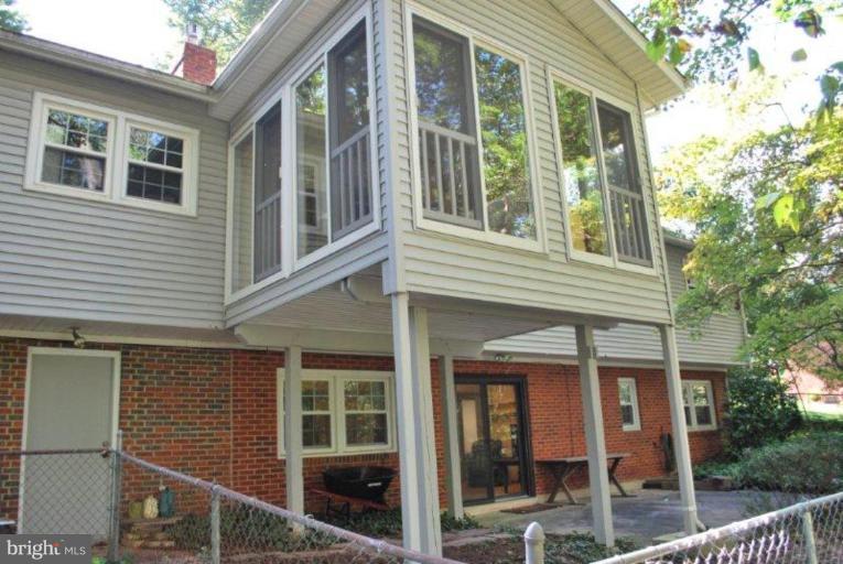 13233 Clifton Road Silver Spring, MD 20904 - Photo 30 of 30 a view of a brick house with large windows and a large tree