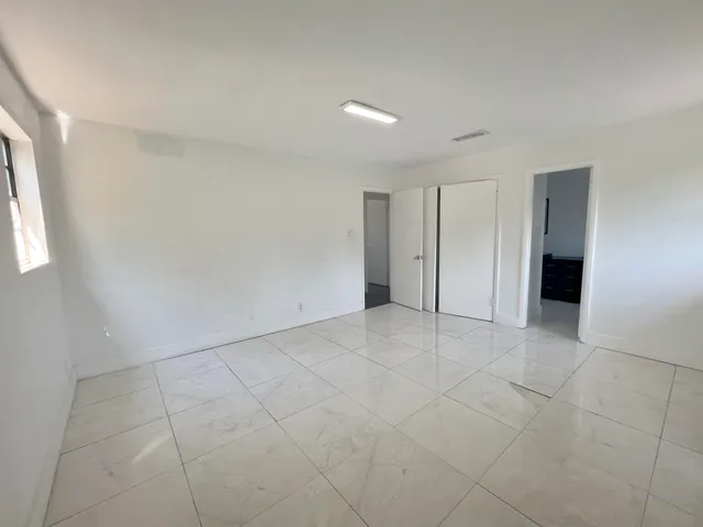 a view of an empty room with a kitchen