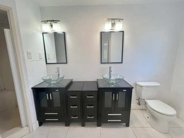 a bathroom with double sink and a toilet