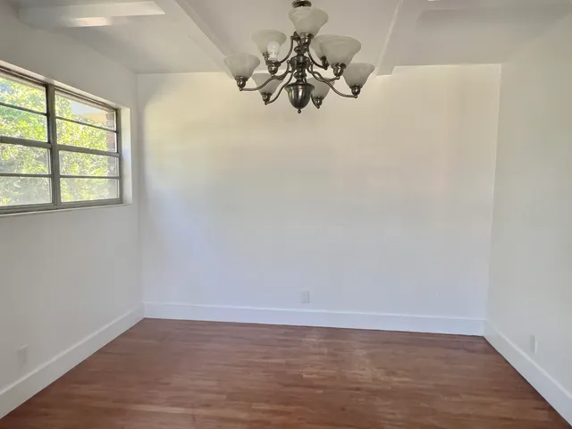 a view of a room with wooden floor and a window