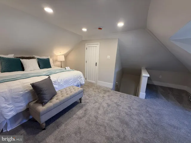 a spacious bedroom with a bed and a lamp