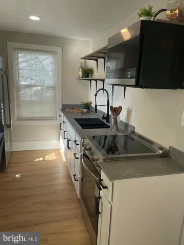 a kitchen with stainless steel appliances granite countertop a sink and a stove