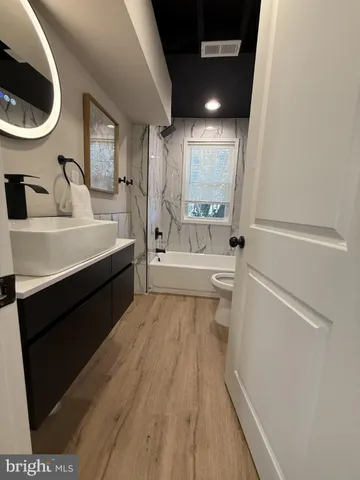 a bathroom with a sink a toilet and a mirror