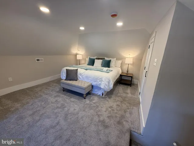 a spacious bedroom with a bed and a cabinets