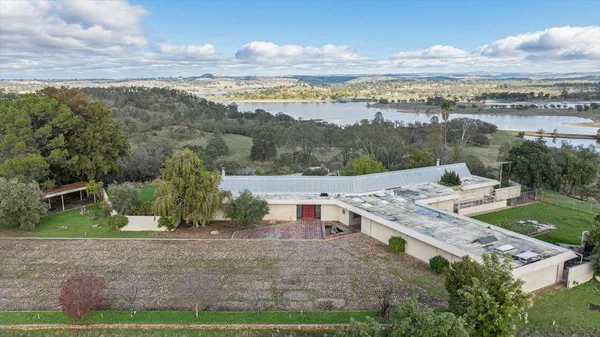 an aerial view of a house with a yard and lake view