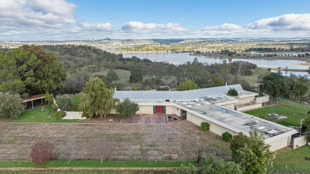an aerial view of a house with a yard and lake view