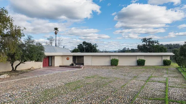 a view of an empty room with wooden floor and fireplace