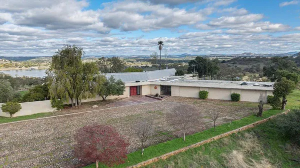 an aerial view of a house with a yard and large trees