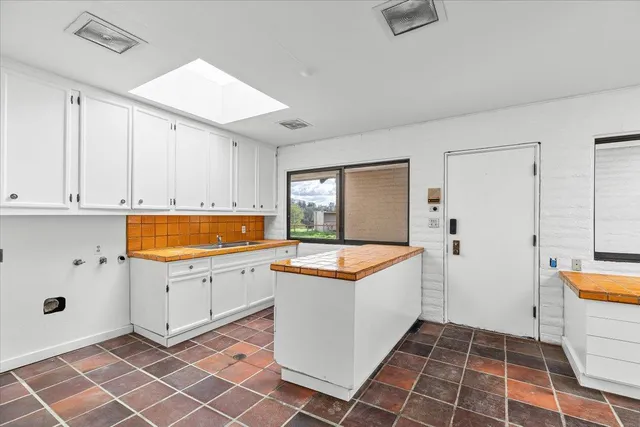 a view of a yard with flower plants and large tree