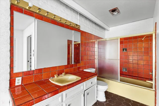 a view of a house with a large window and a yard with plants and large tree