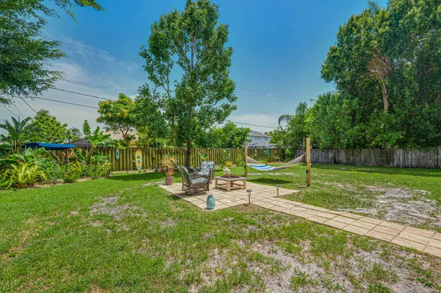 a view of a house with backyard and a tree