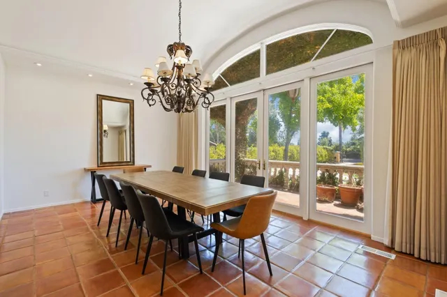 a dining room with furniture a chandelier and window