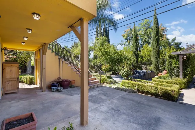 a view of a patio with couches table and chairs and potted plants