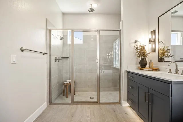 a bathroom with a shower sink and mirror