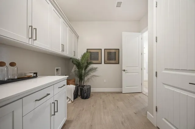 a large living room with stainless steel appliances kitchen island granite countertop a large kitchen island a stove a sink a dining table and chairs with wooden floor