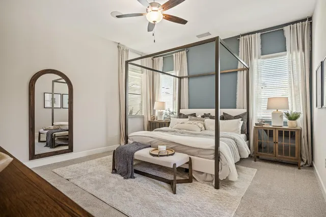 a bedroom with a bed a table and with the view mirror