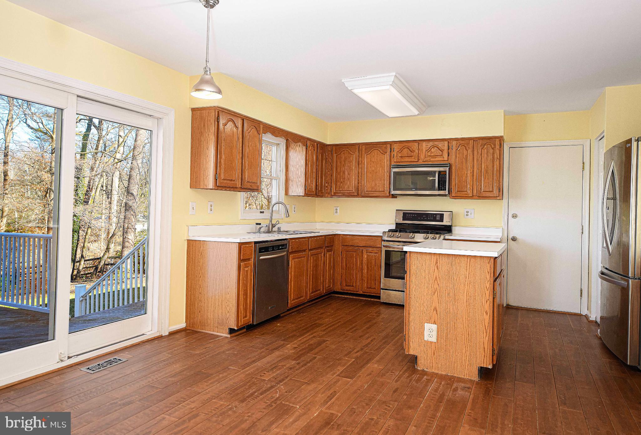 644 Symphony Woods Drive Silver Spring, MD 20901 - Photo 20 of 53 a kitchen with stainless steel appliances granite countertop a refrigerator a sink dishwasher a stove with wooden floor and cabinets