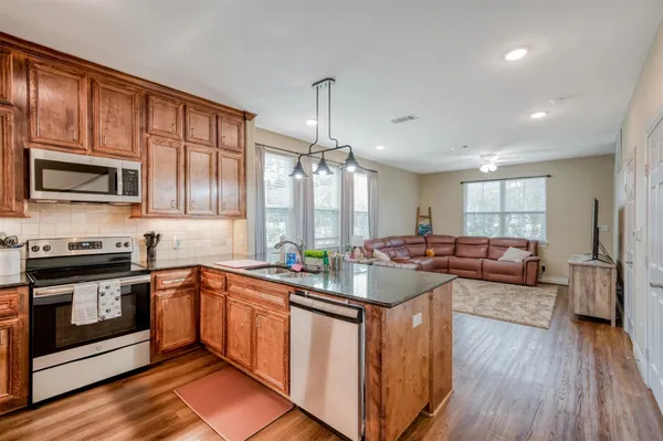 a kitchen with lots of counter top space a sink appliances and cabinets