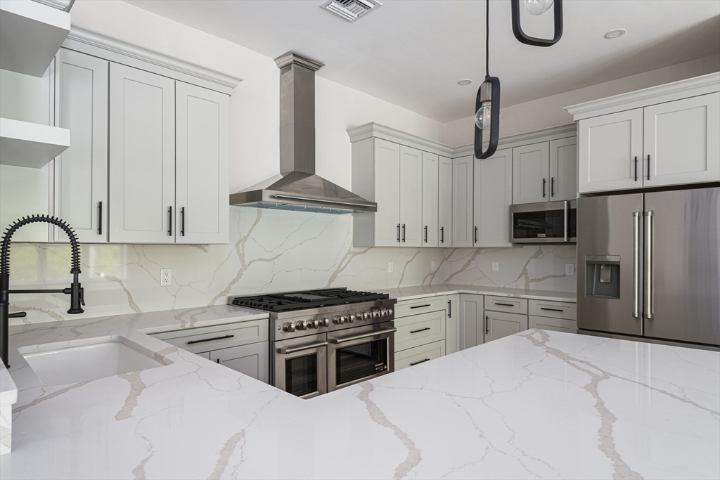 68 Richard Circle Seekonk, MA 02771 - Photo 23 of 40 a kitchen with stainless steel appliances a stove a sink and white cabinets
