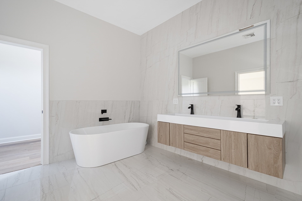 68 Richard Circle Seekonk, MA 02771 - Photo 27 of 40 a bathroom with a white tub a sink and mirror