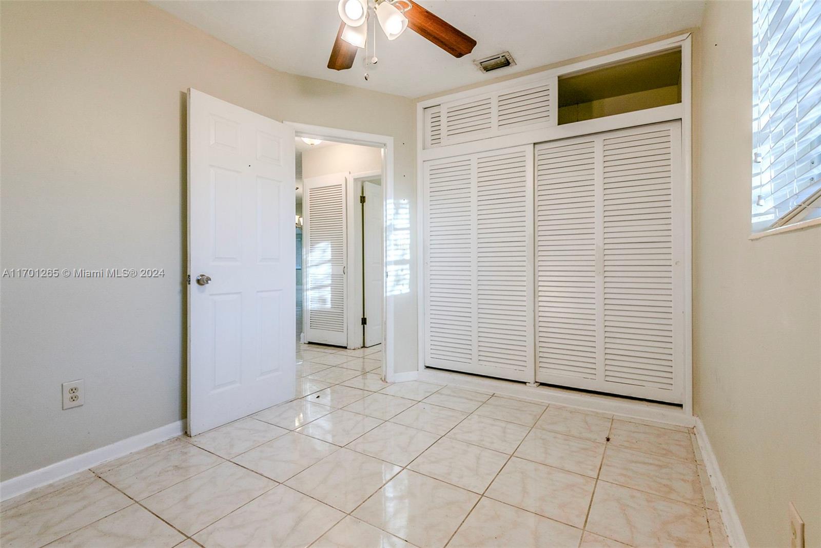 14281 Southwest 285th Street Homestead, FL 33033 - Photo 13 of 27 an empty room with windows and chandelier fan