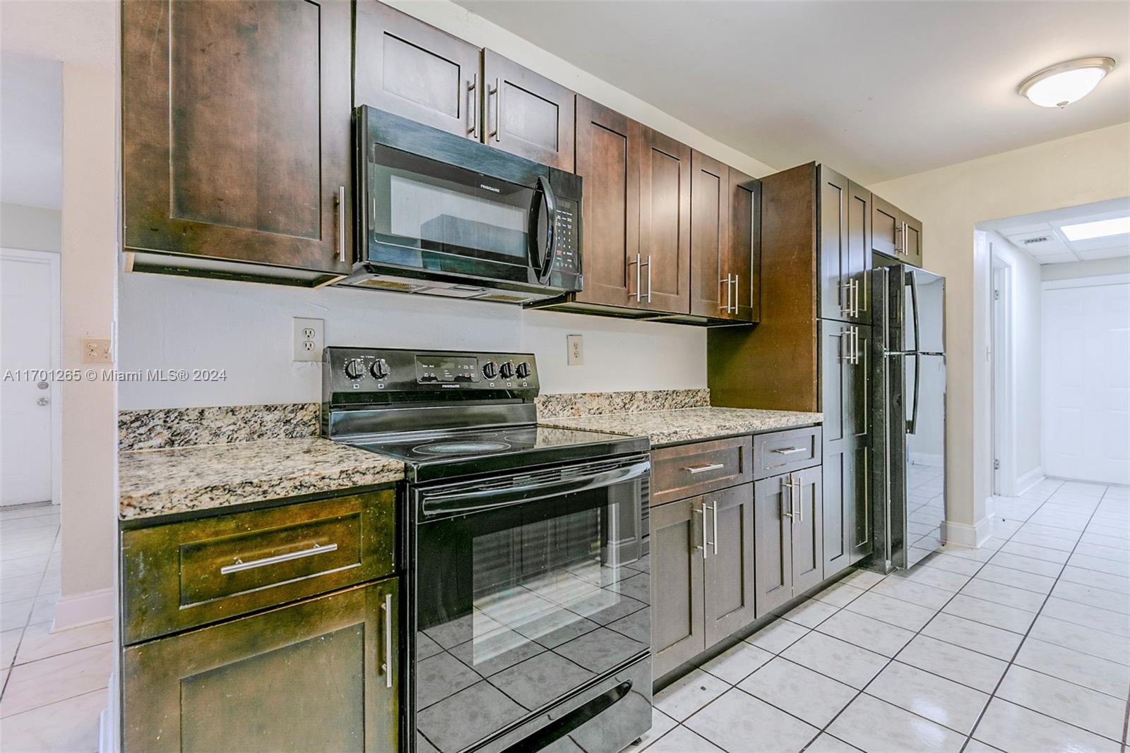 14281 Southwest 285th Street Homestead, FL 33033 - Photo 10 of 27 a kitchen with stainless steel appliances granite countertop a stove microwave and refrigerator