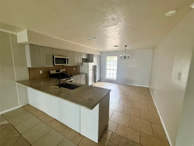 a kitchen with a sink a microwave and cabinets