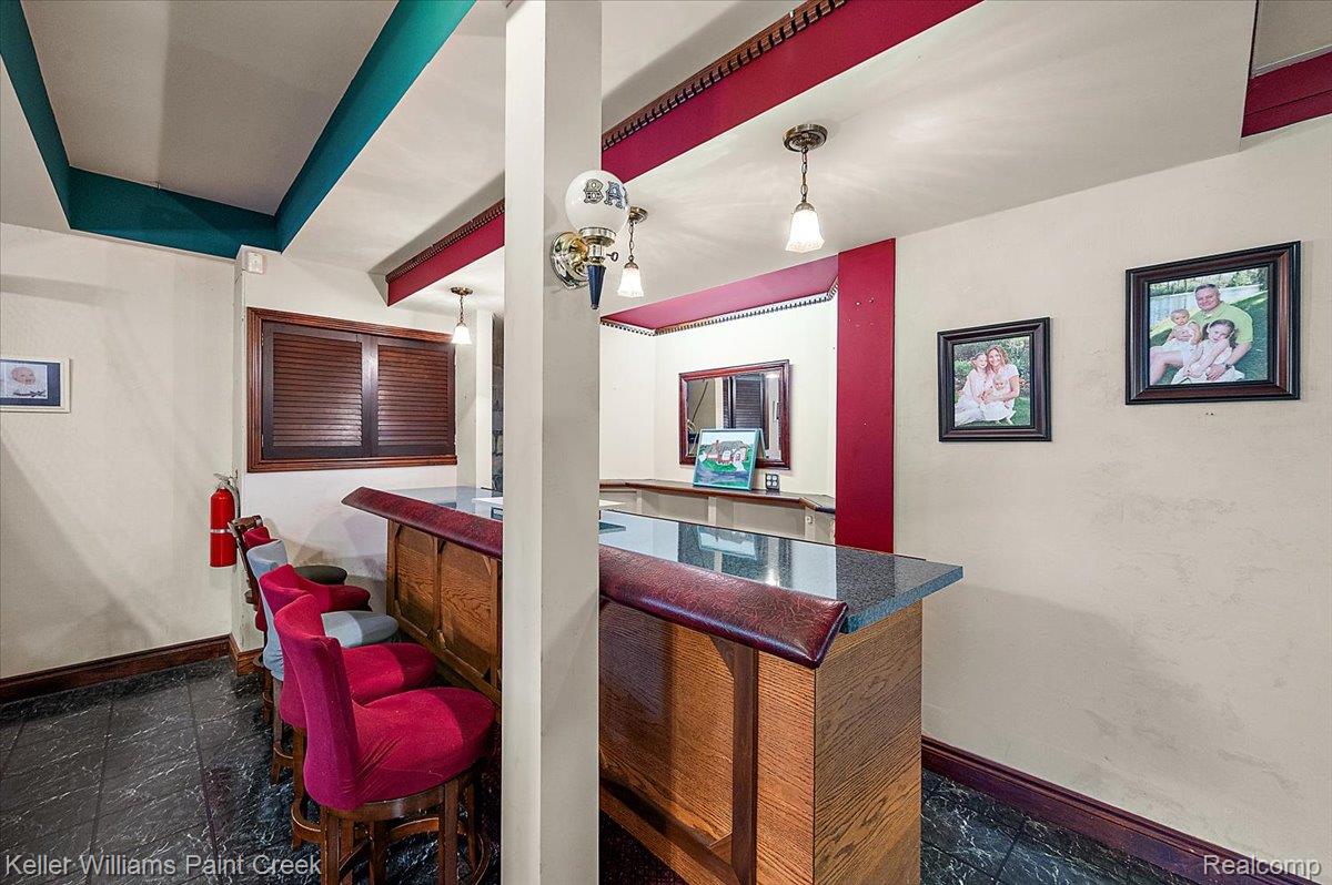 69069 Campground Road Romeo, MI 48065 - Photo 73 of 78 Custom bar area featuring a wood-finish bar, dark countertop, and black tile flooring