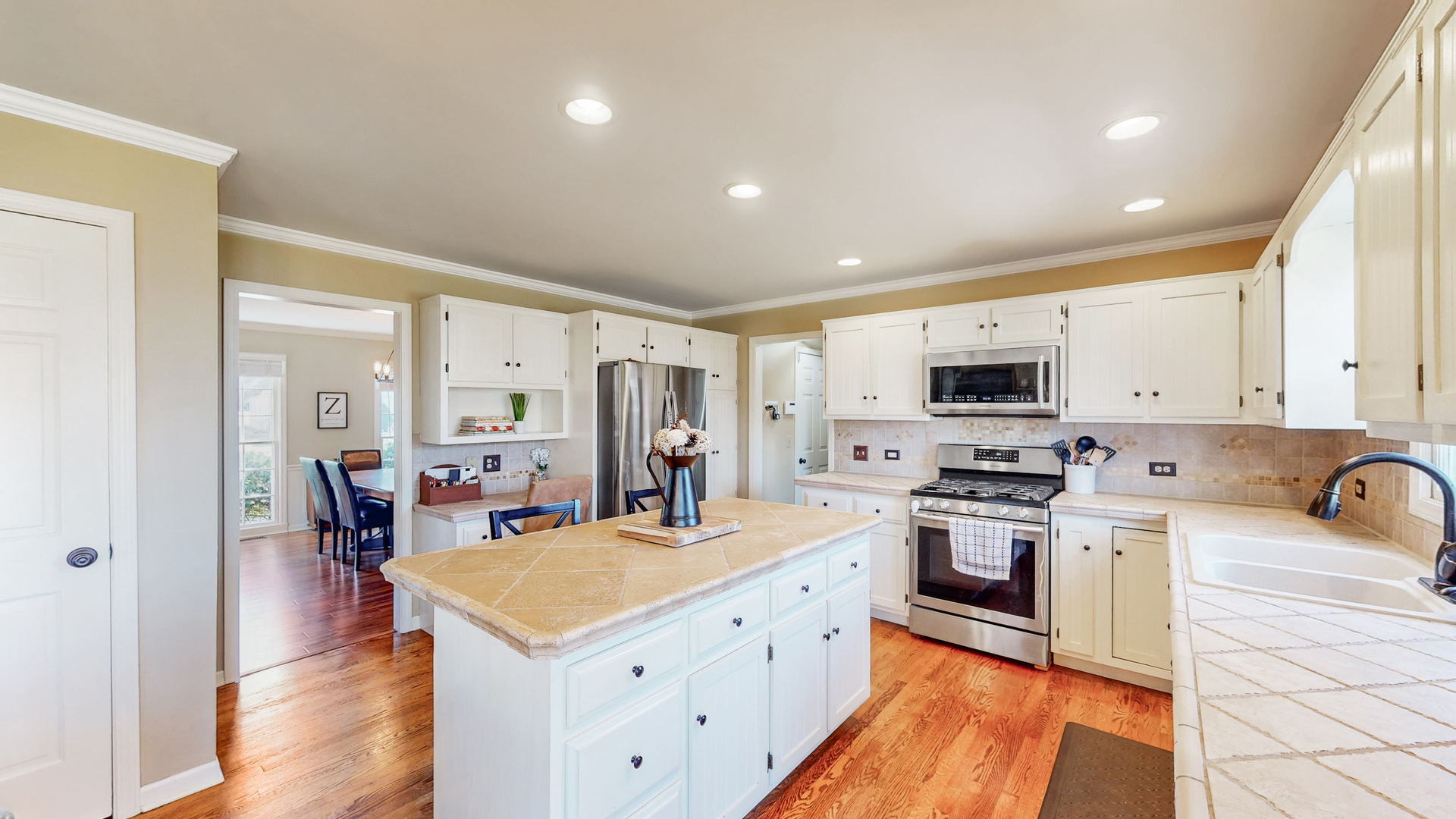 821 South River Road Naperville, IL 60540 - Photo 7 of 32 a kitchen with stainless steel appliances granite countertop a stove top oven a sink a refrigerator and white cabinets with wooden floor