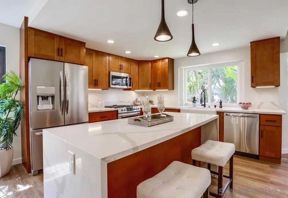 916 Alyssum Road Carlsbad, CA 92011 - Photo 17 of 42 a kitchen with stainless steel appliances granite countertop a sink a stove a refrigerator cabinets and chairs