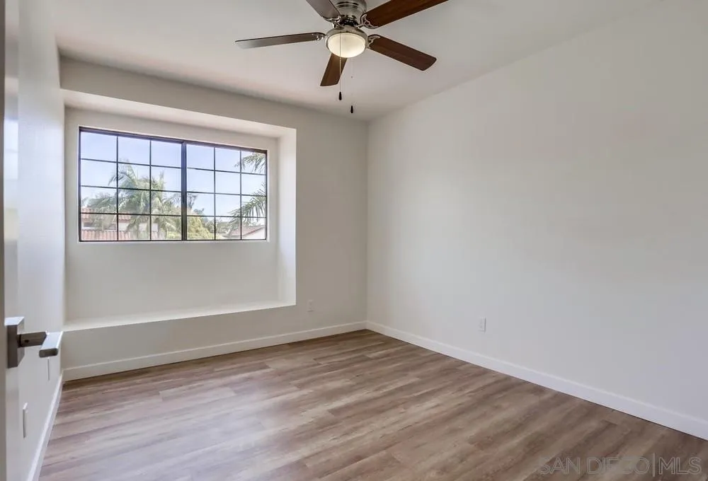 916 Alyssum Road Carlsbad, CA 92011 - Photo 30 of 42 an empty room with wooden floor and windows
