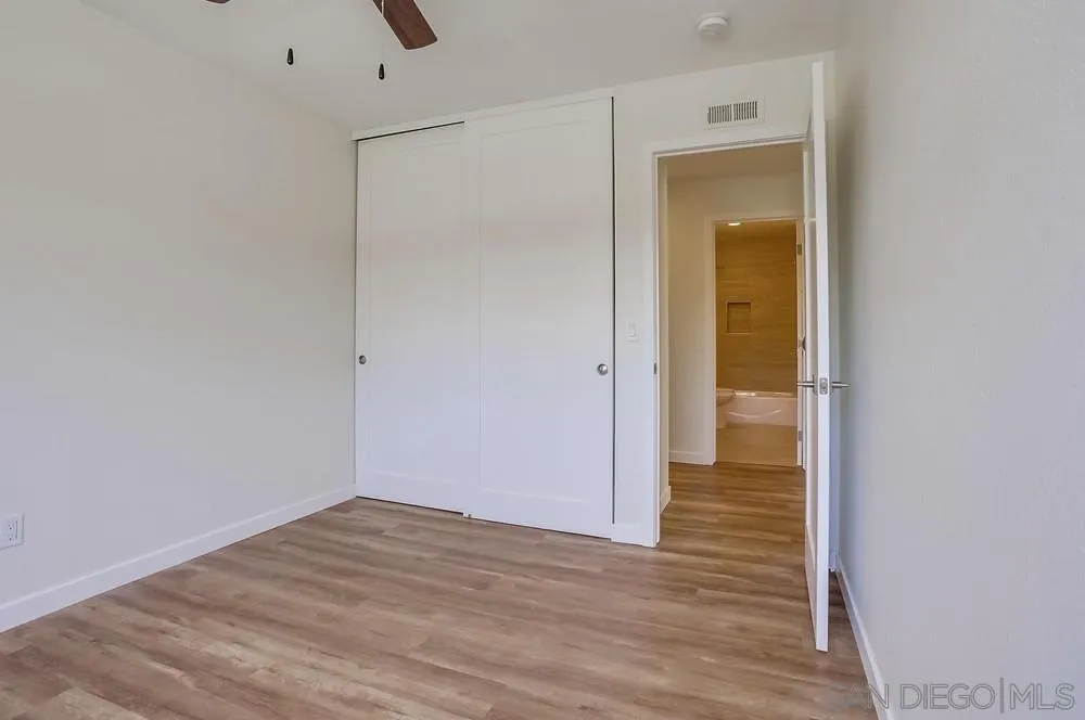 916 Alyssum Road Carlsbad, CA 92011 - Photo 31 of 42 a view of an empty room with wooden floor and a bathroom