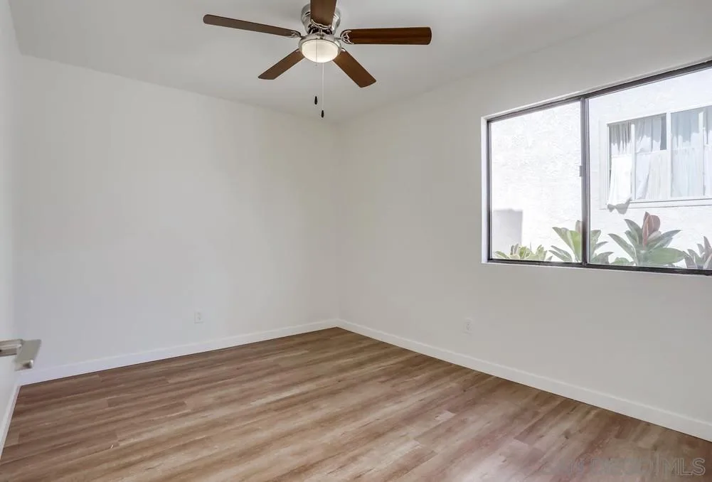916 Alyssum Road Carlsbad, CA 92011 - Photo 34 of 42 an empty room with wooden floor fan and windows
