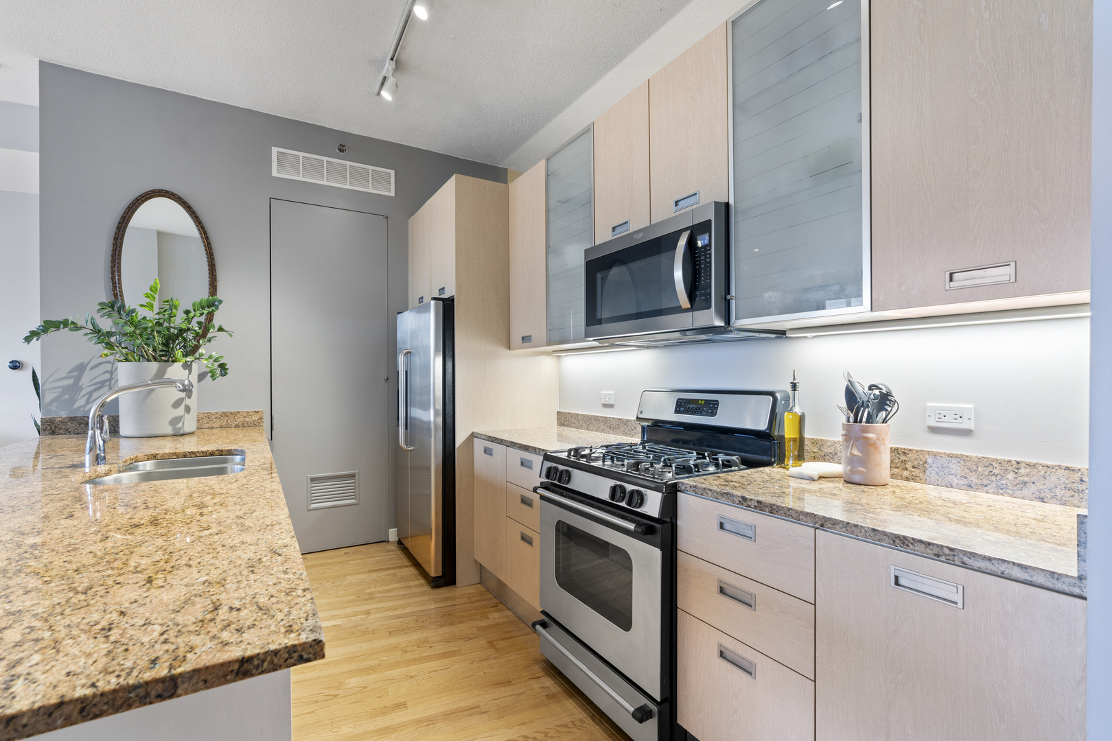 950 West Erie Street, Unit 602 Chicago, IL 60642 - Photo 5 of 18 a kitchen with granite countertop a sink stainless steel appliances and cabinets
