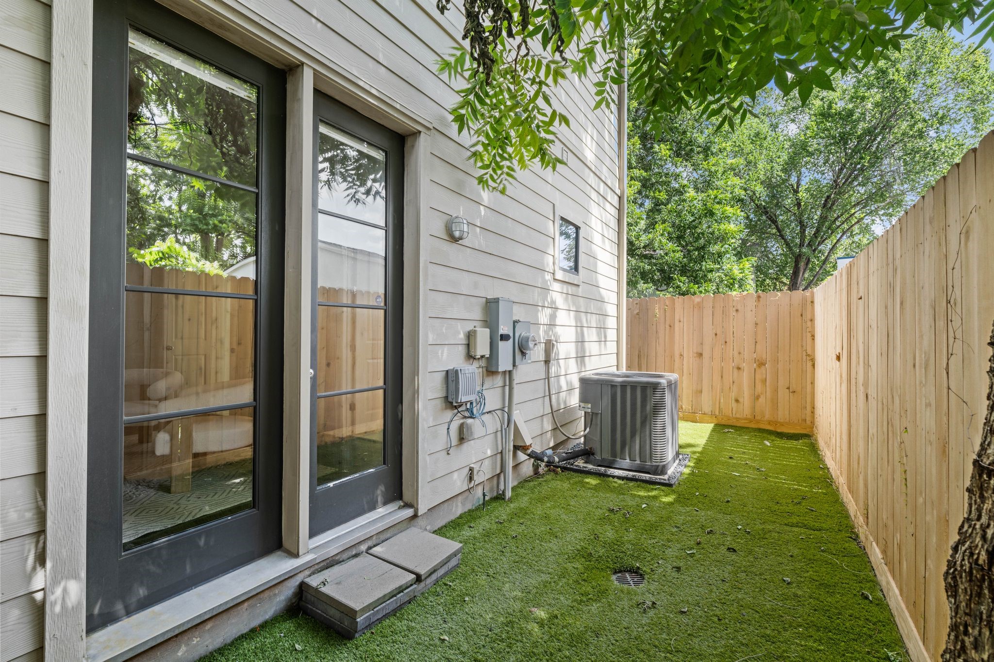 908 Thompson Street Houston, TX 77007 - Photo 6 of 45 French doors from the secondary bedroom open to a secluded outdoor space, complete with artificial turf and new fencing.