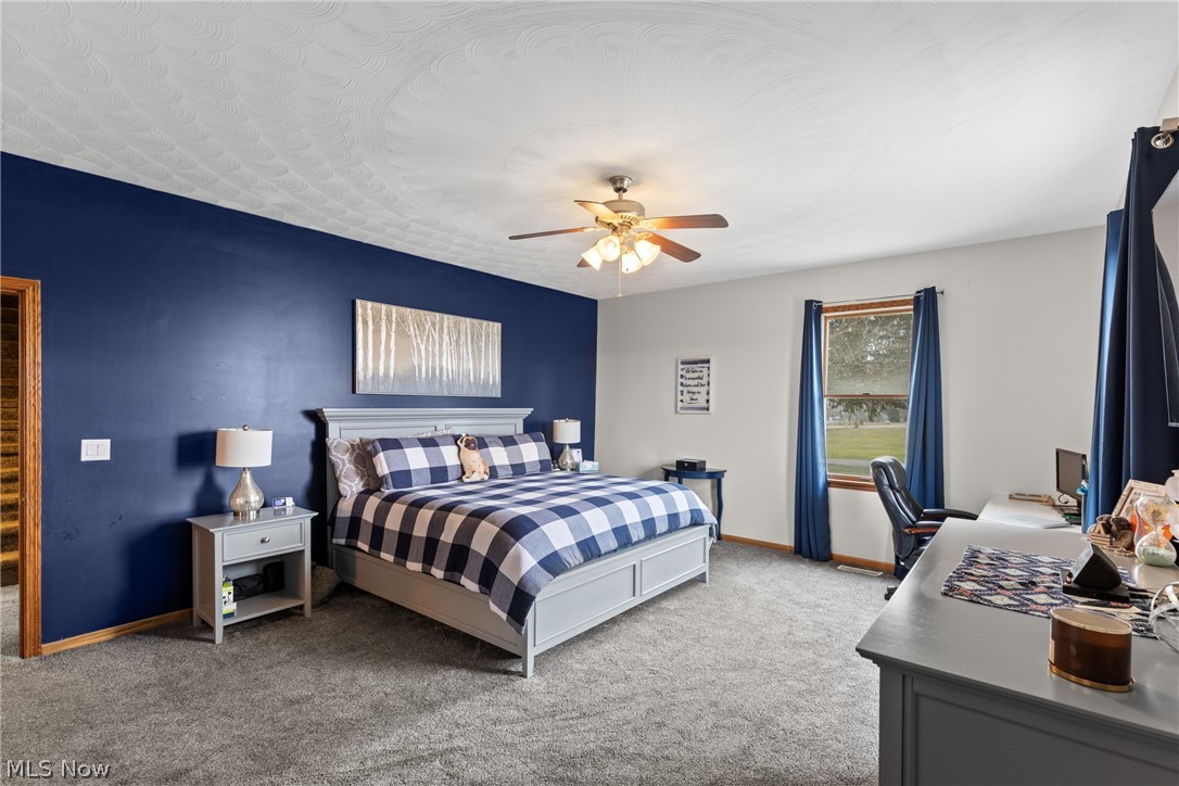64508 Slade Road Cambridge, OH 43725 - Photo 18 of 50 1st floor primary Bedroom featuring light colored carpet, a ceiling fan, and an office area