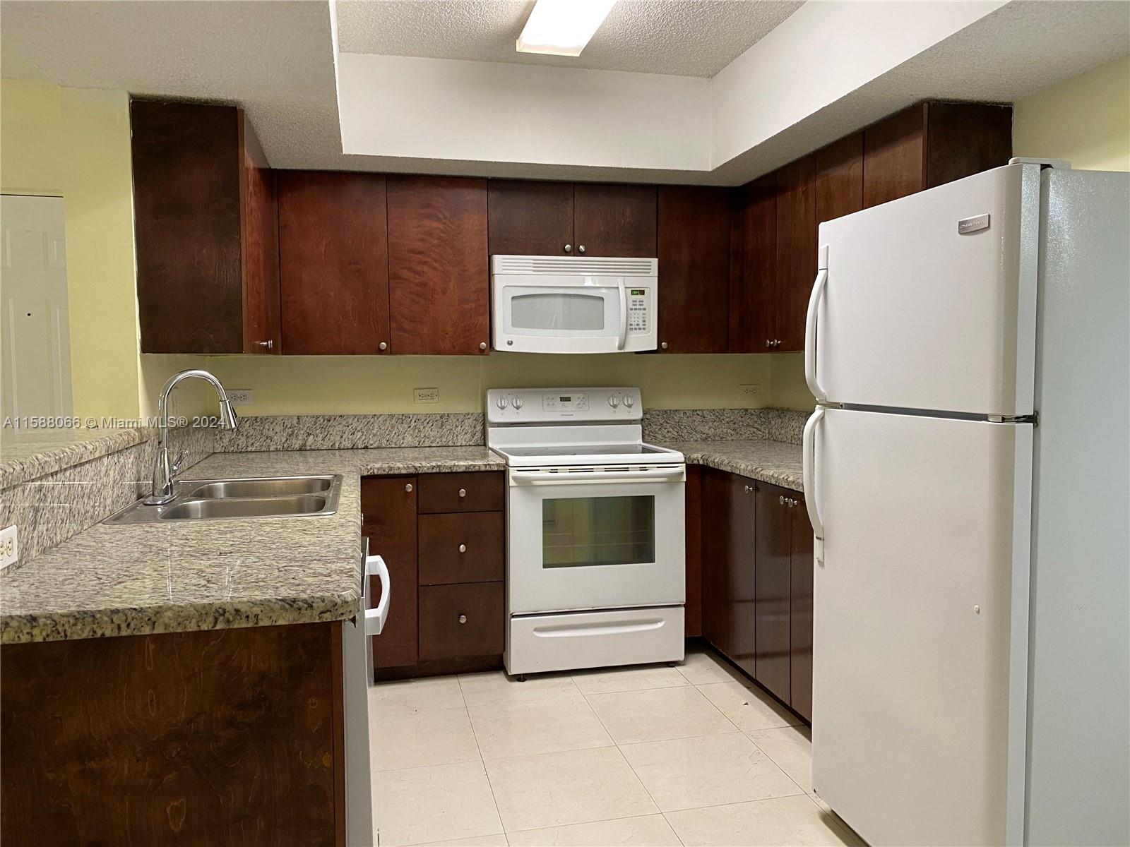 a kitchen with a refrigerator sink and stove