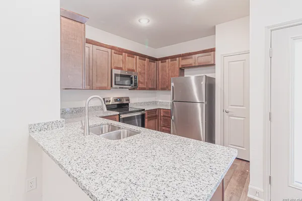a kitchen with granite countertop a refrigerator stove and microwave