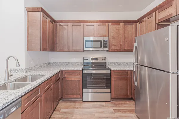 a kitchen with stainless steel appliances granite countertop a sink a stove and cabinets